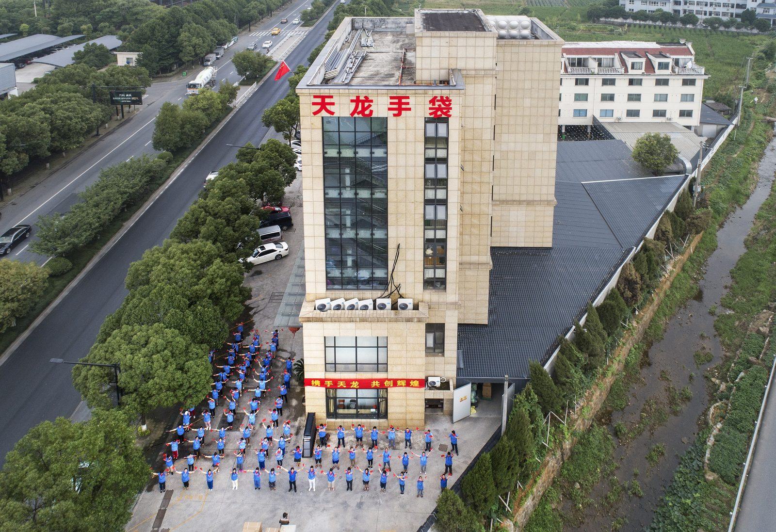 Aerial view of the factory in Fuyang, Hangzhou, with the original 天龙手袋 sign and staff gathered outside