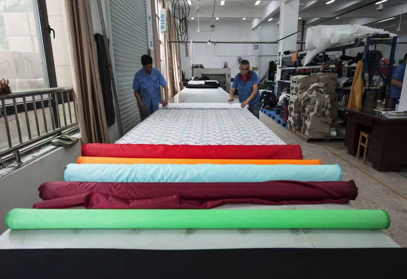 Rolls of colored fabric on the spreading table